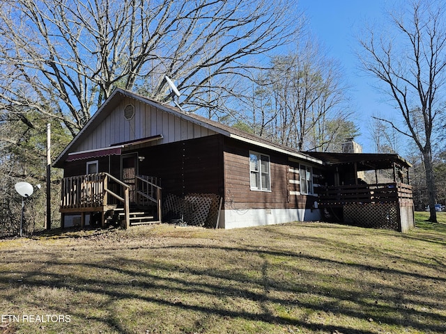 view of side of home featuring a chimney and a lawn