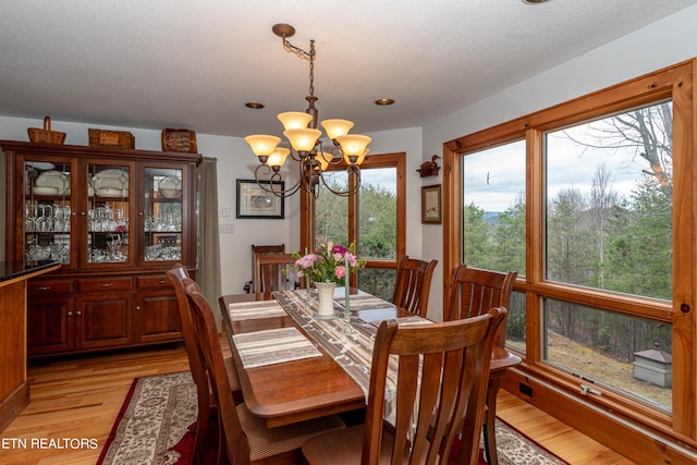 dining room with light wood-type flooring and a chandelier