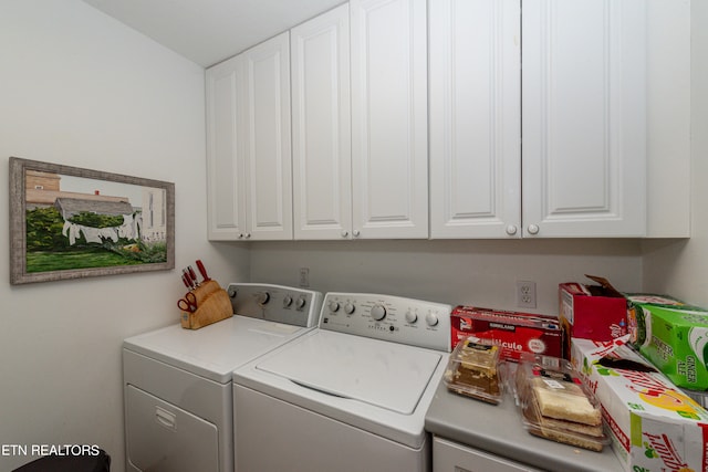 washroom featuring cabinets and washing machine and clothes dryer