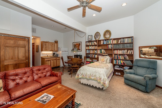 carpeted bedroom with ceiling fan, sink, beamed ceiling, white fridge, and a closet