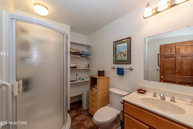 bathroom with vanity, toilet, and a shower with shower door