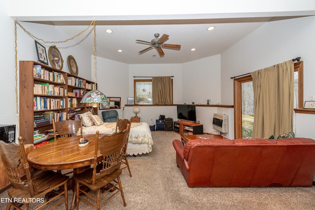 living room with ceiling fan, light carpet, and heating unit