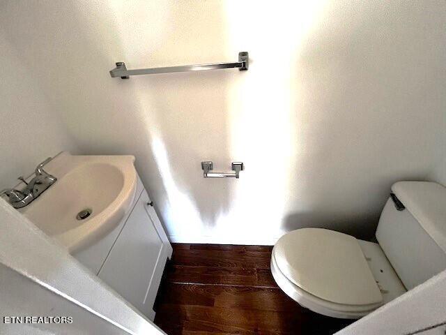 bathroom with toilet, hardwood / wood-style flooring, and vanity