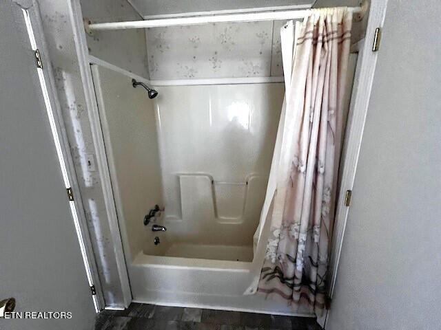 bathroom with shower / bathtub combination with curtain