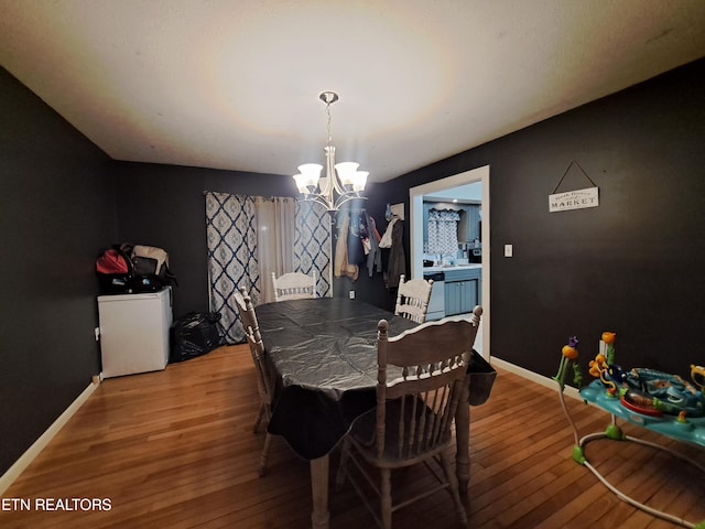 dining area with an inviting chandelier and hardwood / wood-style flooring