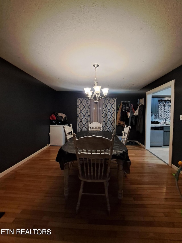 dining space featuring a notable chandelier, a textured ceiling, and dark hardwood / wood-style flooring