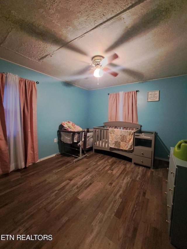 unfurnished bedroom featuring ceiling fan, dark wood-type flooring, and a textured ceiling