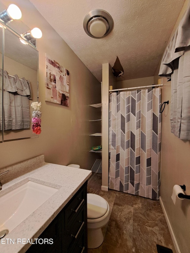 bathroom featuring tile flooring, toilet, vanity, and a textured ceiling