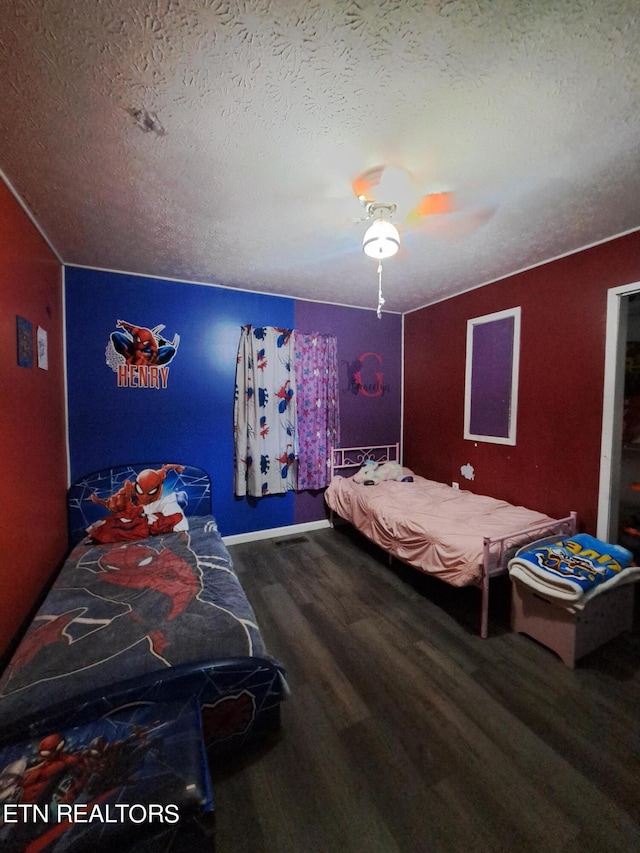 bedroom with ceiling fan, dark hardwood / wood-style floors, and a textured ceiling