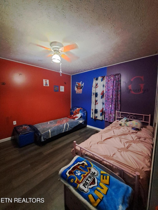 unfurnished bedroom featuring dark hardwood / wood-style flooring, ceiling fan, and a textured ceiling