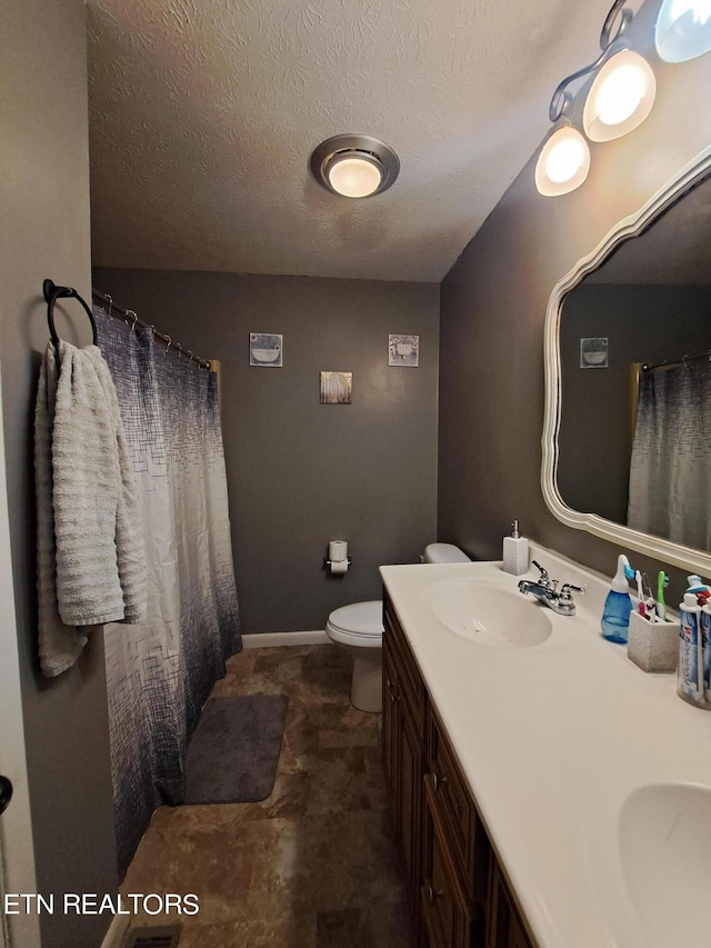 bathroom with toilet, tile floors, and dual vanity