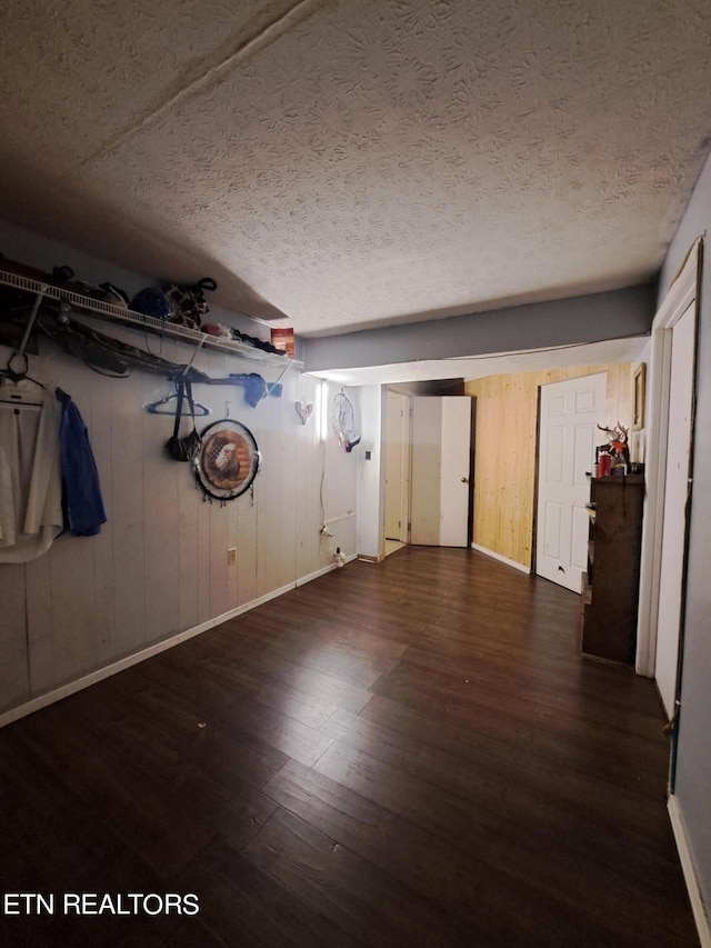 interior space with a textured ceiling and dark hardwood / wood-style floors