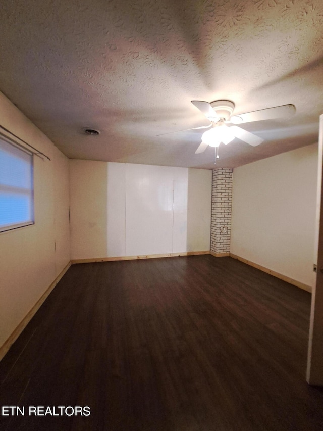 unfurnished room with ceiling fan, a textured ceiling, and dark hardwood / wood-style flooring