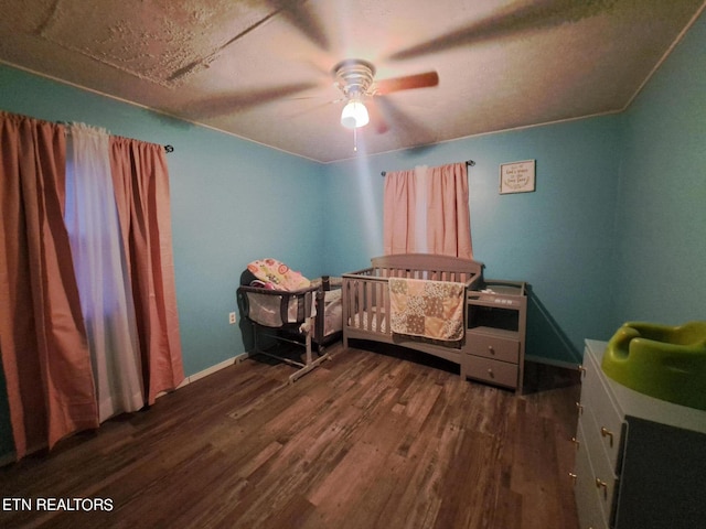 bedroom with a textured ceiling, ceiling fan, and dark wood-type flooring