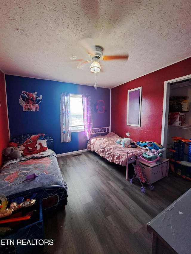 bedroom featuring ceiling fan, a textured ceiling, and dark wood-type flooring