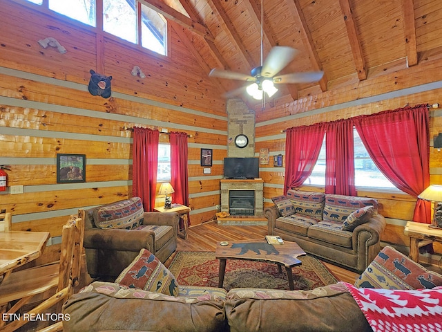 living room with ceiling fan, hardwood / wood-style floors, wooden ceiling, wood walls, and a fireplace