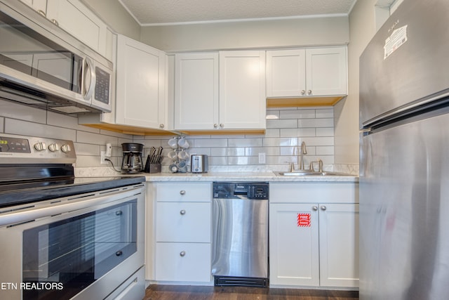 kitchen with dark hardwood / wood-style floors, white cabinetry, tasteful backsplash, and appliances with stainless steel finishes