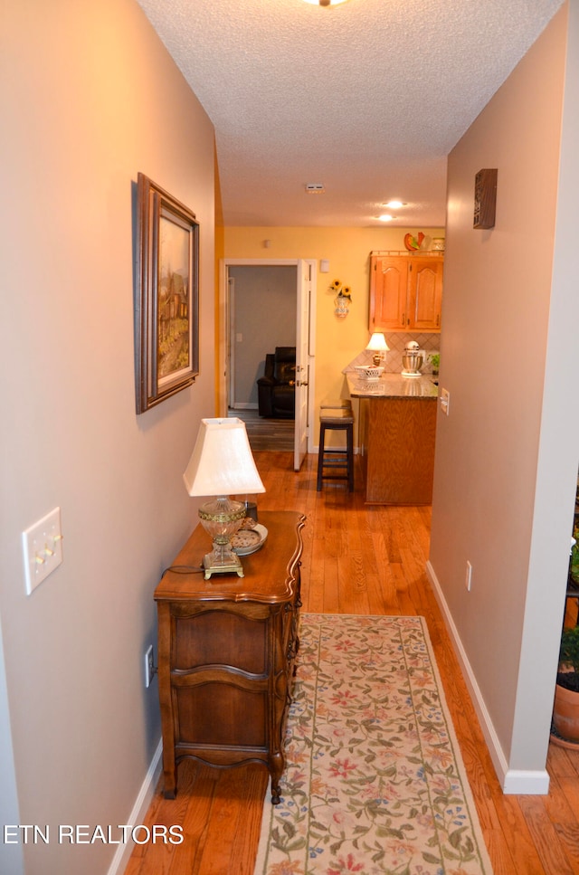 corridor featuring hardwood / wood-style flooring and a textured ceiling