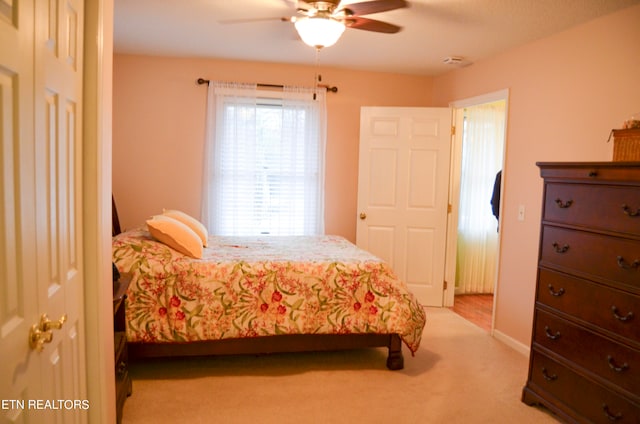 carpeted bedroom with ceiling fan and a closet