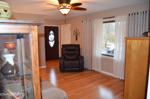 living area featuring wood-type flooring and ceiling fan