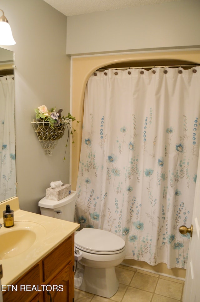 bathroom with vanity, toilet, and tile floors