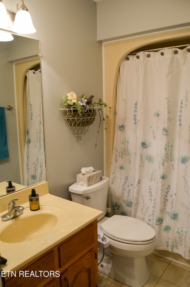 bathroom with toilet, tile floors, and large vanity