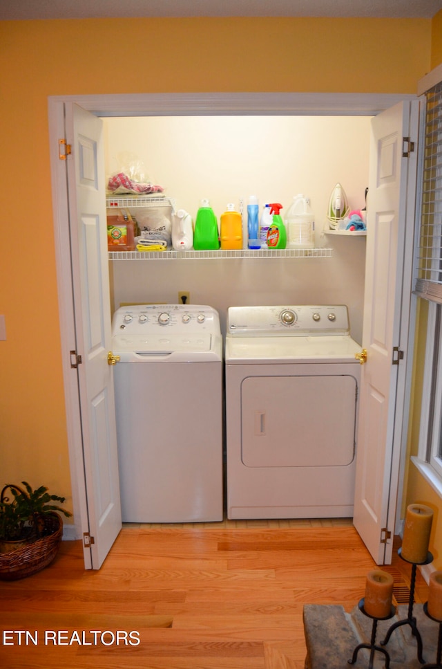 laundry area featuring independent washer and dryer and light hardwood / wood-style floors