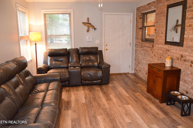 living room with hardwood / wood-style flooring and brick wall