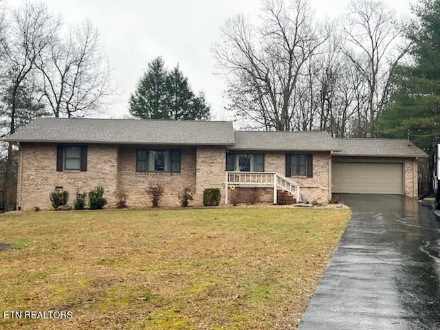 single story home featuring a garage and a front yard