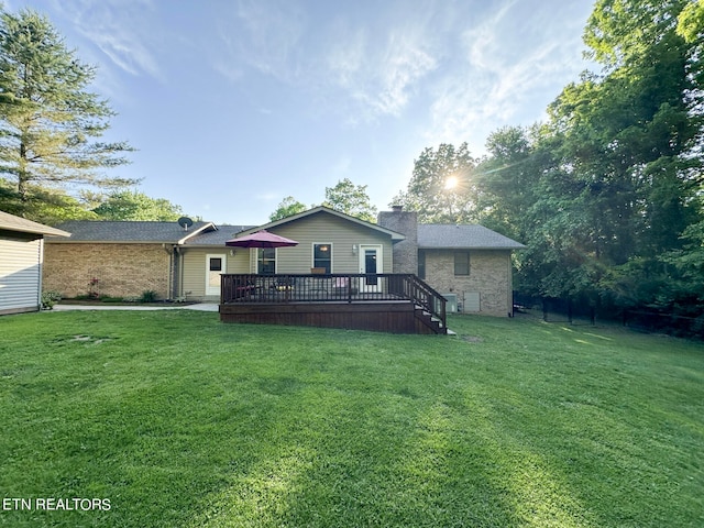 back of house featuring a deck and a yard