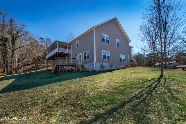 back of property featuring a wooden deck and a lawn