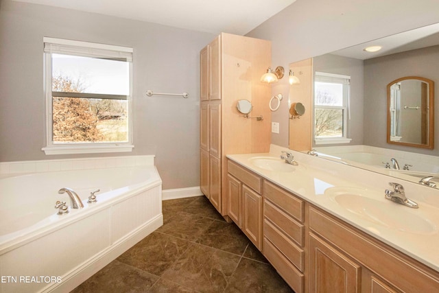 bathroom with a washtub, dual vanity, and tile flooring