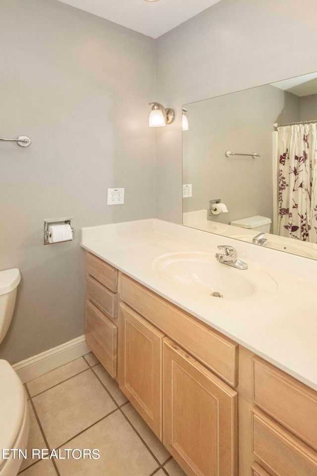 bathroom with tile flooring, vanity, and toilet