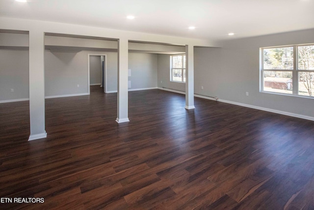 basement featuring dark hardwood / wood-style flooring and a baseboard heating unit