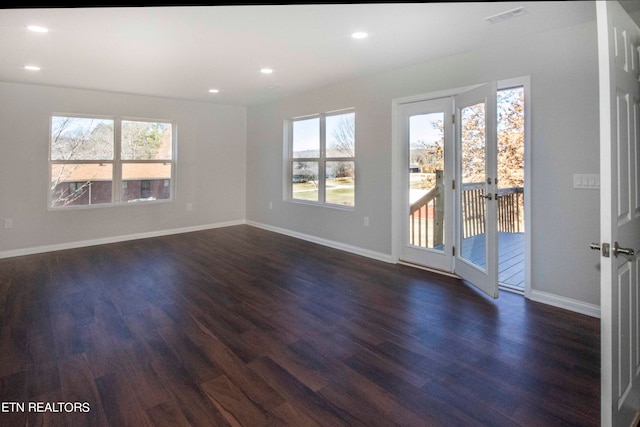 spare room featuring french doors, plenty of natural light, and dark hardwood / wood-style flooring