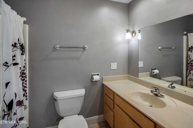 bathroom with large vanity, toilet, and tile flooring