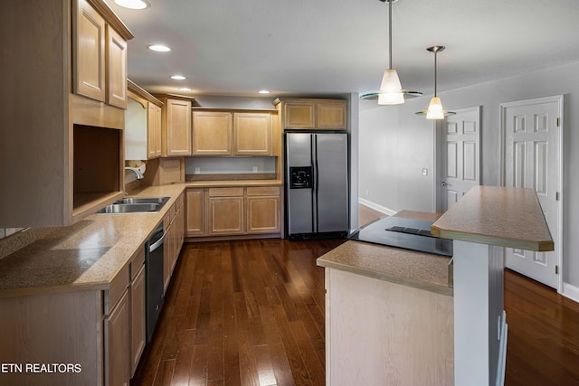 kitchen featuring a kitchen breakfast bar, hanging light fixtures, dark wood-type flooring, stainless steel appliances, and sink