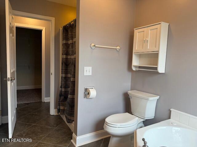 bathroom with baseboards, a shower with shower curtain, toilet, and tile patterned flooring