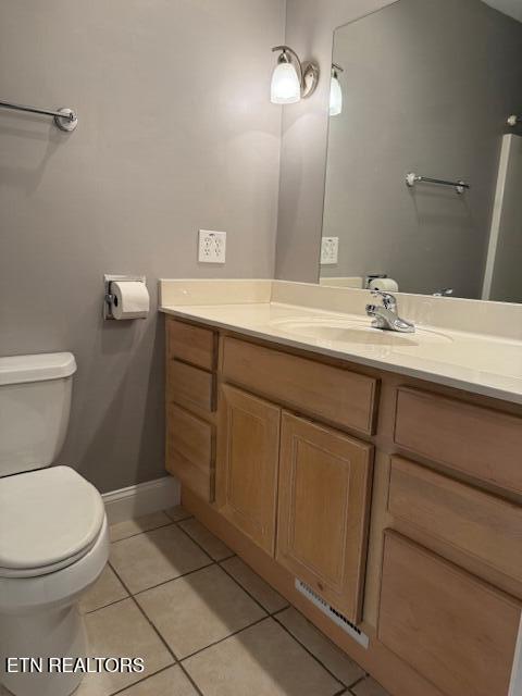 bathroom with baseboards, toilet, tile patterned flooring, and vanity