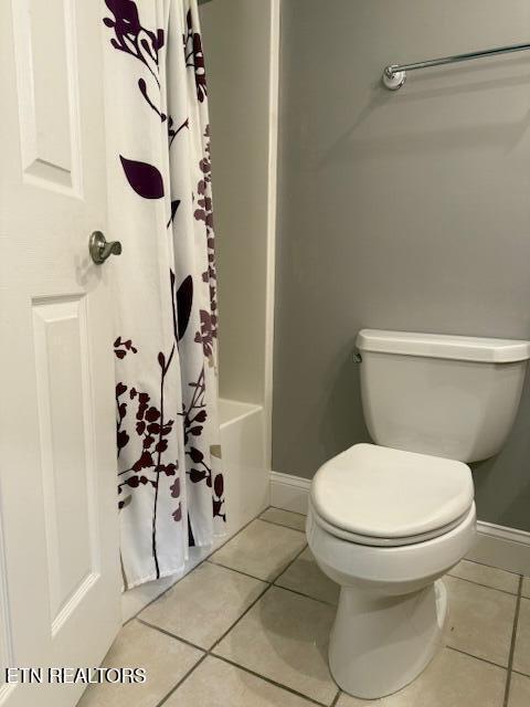 full bath featuring baseboards, shower / tub combo with curtain, toilet, and tile patterned flooring