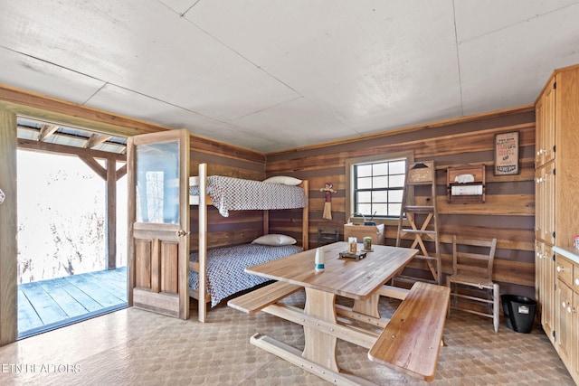 bedroom with wood walls and access to exterior