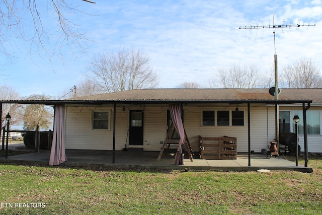 back of house featuring a lawn and a patio area