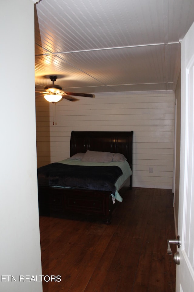 bedroom with dark hardwood / wood-style flooring, billiards, ceiling fan, and a fireplace