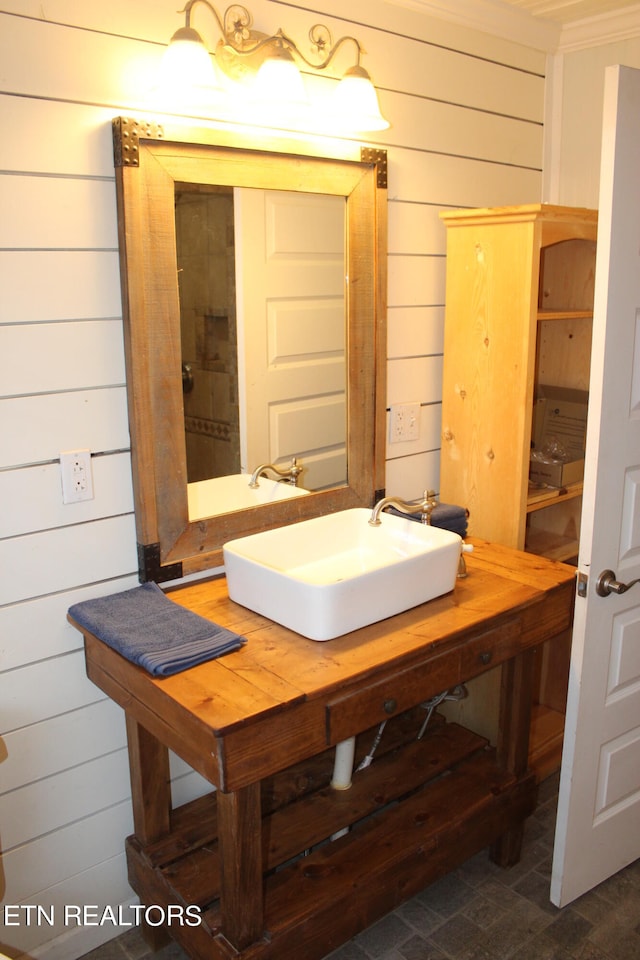 bathroom featuring wood walls and sink