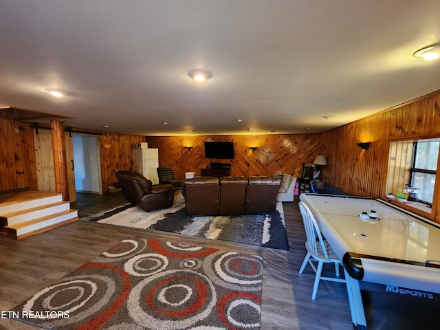 living room with dark hardwood / wood-style floors and wooden walls