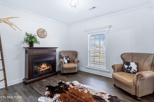 sitting room with dark hardwood / wood-style flooring and ornamental molding