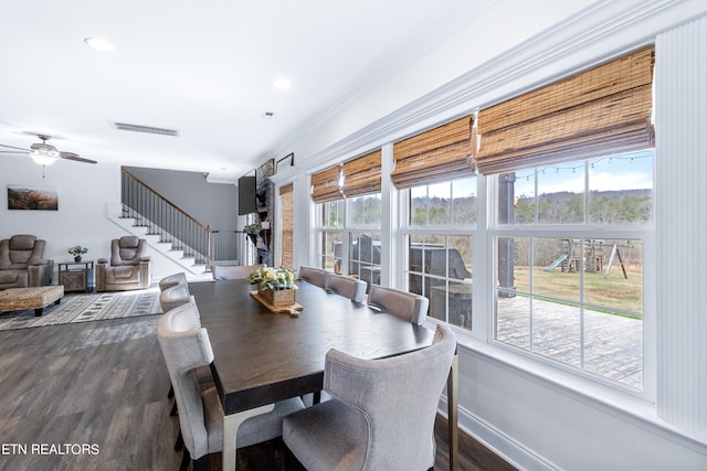 dining space with crown molding, ceiling fan, dark wood-type flooring, and a wealth of natural light