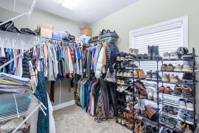 walk in closet featuring light colored carpet