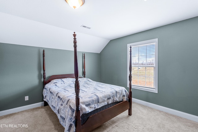 bedroom featuring light carpet and vaulted ceiling