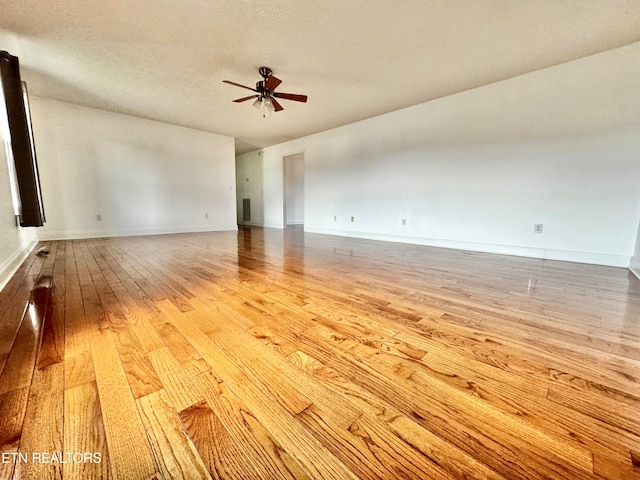 unfurnished room featuring a textured ceiling, ceiling fan, and light hardwood / wood-style flooring